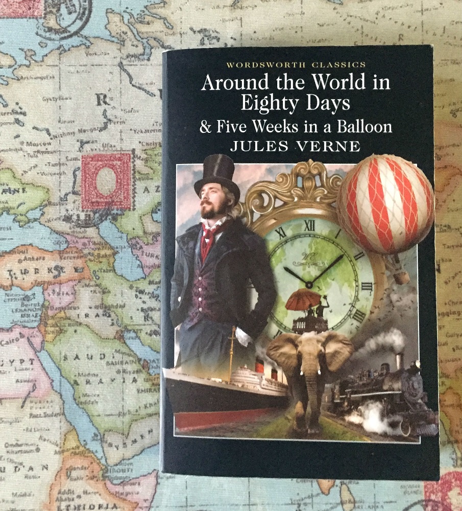 Het boek Around the world in eigthy days van Jules Verne op een wereldkaart